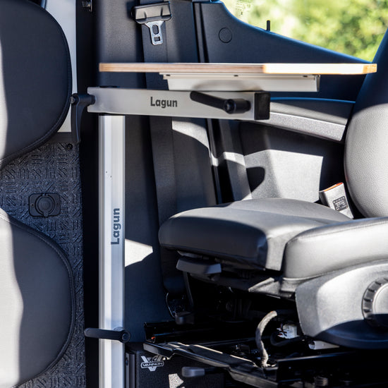Van interior with a retractable table labeled 'Lagun' and a seat folded down.