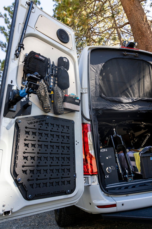 MOLLE panels mounted on the rear door of a Sprinter Van, equipped with various gear and storage solutions.