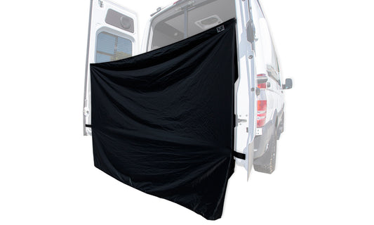 A black shower curtain installed on the rear side of a white VANNON van.