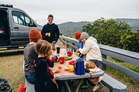 VANNON-equipped van parked in a scenic summer location with people enjoying outdoor living.
