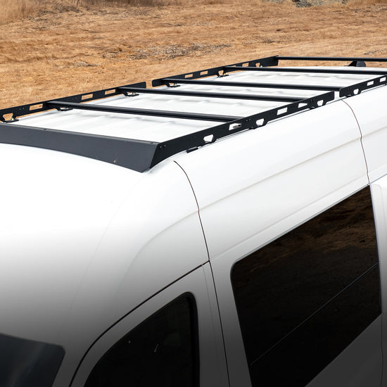 Black aluminum roof rack installed on the roof of a white van