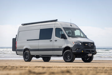 Van on a beach with ocean in the background